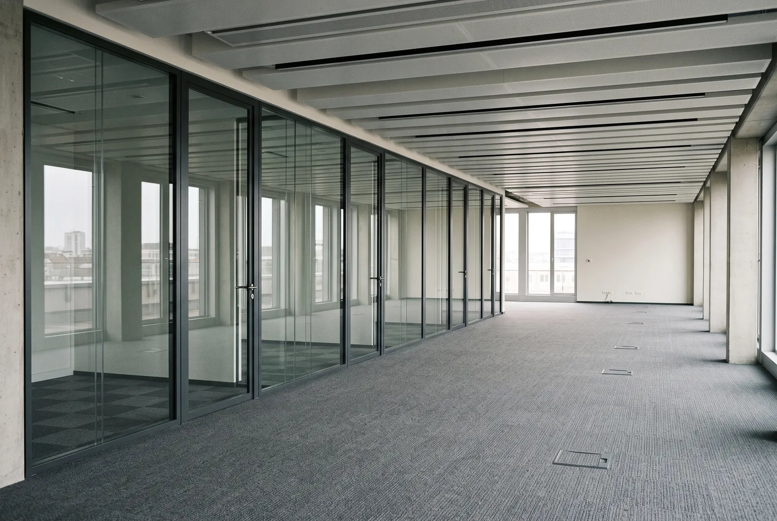 Illustration : plateau de bureaux aménagé avec cloisons vitrées et faux plafond acoustique